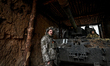 Artillerymen of Ukraine's 118th Separate Mechanized Brigade stand by a self-propelled howi...