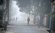 People travel to work and students go to school on a cold and foggy day in Siliguri, India...