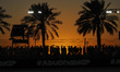 Silhouettes of the crowd, people and fans from around the world next to palm trees during...