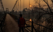 A boy walks as the sun appears on a cold winter day in Baramulla, Jammu and Kashmir, India...