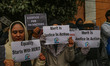 Students hold placards during a protest outside the chief minister's residence to demand r...