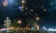 People gather to look at fireworks as they celebrate the New Year at Padang Beach in West...
