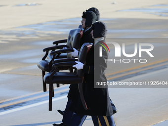 U.S. Air Force Airmen carry chairs for attendees at the state funeral arrival ceremony of former U.S. President Jimmy Carter at Joint Base A... by Bryan Dozier/NurPhoto