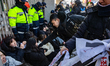 Twelve members of The Korean University Students Progressive Union protest in front of the...