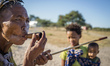 The San woman smoking wooden pipe in the Living Museum of the Ju’Hoansi-San, Grashoek, Nam...