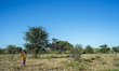 Mother with her child going to the village of the Living Museum of the Ju’Hoansi-San, Gras...