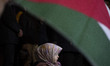 A young Iranian girl stands under a Palestinian flag during a gathering at Palestine Squar...