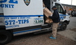NYPD Police Crime Scene Unit investigators bring out evidence boxes and evidence bags at 1...
