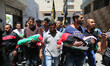 People carry the bodies of three children, namely Nasir, Rehaf and Yusra El Hundi, who los...