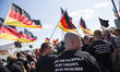Right-wing activists hold banners and scream slogans during a demonstration to protest und...
