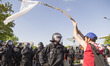 A left-wing protester holds a white banner in front of policemen during a protest against...