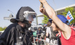 A left-wing protester holding a white banner (not in the picture) speaks with a policeman...