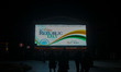 Tourists and local people look at an electronic board that flashes a 76th Happy Republic D...