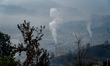 Smoke emanates from the traditional chimneys of a brick factory on the outskirts of Kathma...