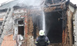 A firefighter puts out a fire in a house damaged by a Russian drone strike in Kharkiv, Ukr...