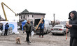 People receive building materials to repair their homes damaged by a massive Russian kamik...