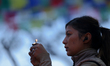 A woman lights the butter lamp dedicated to the goddess Saraswati during the annual festiv...