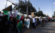 A group of demonstrators marches down the street during a protest against Trump immigratio...