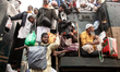 Thousands of Muslim devotees return home on an overcrowded train after attending the final...