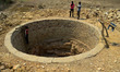 Indian laborers work inside a dried well as he digs to reach on water level as people of P...