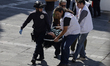 Members of Doctors Without Borders transfer a migrant on a stretcher to an ambulance at a...