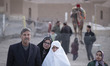 An elderly Iranian woman wearing a white veil stands with her family in a tourism camp in...