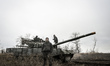 A soldier stands in front of a T-72 tank during a live fire exercise of a tank battalion o...