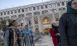 Iranian tourists walk together in the Abbasi Hotel, surrounded by Safavid architectural st...