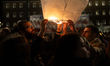 People gather in front of the Hellenic Parliament, releasing lanterns into the sky in hono...