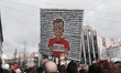 A protester holds a cartoon depicting the Greek Prime Minister in jail clothes, with the n...