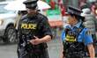 A pair of Ontario Provincial Police constables walk in the rain along Yonge Street during...