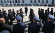 Police officers participate in the swearing-in ceremony of a new group of recruits joining...