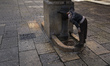 A young man drinks water from a fountain in the Plaza del Fontan in Oviedo, Spain. Its nam...