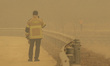 Firefighters watch smoke rise above a mountain at Gilan-Myeon in Andong, South Korea, on M...