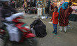 A burqa-clad woman seeks alms as people shop at a market ahead of the Eid Al-Fitr festival...