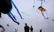 People fly kites while thousands gather at the National Mall during the Blossom Kite Festi...