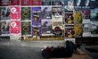 Homeless man sleeps on the pavement in front of posters in Athens, May 13, 2016 