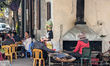 Diners gather at plastic tables along the sidewalk outside a popular restaurant in Thanh H...