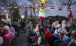 Iranian families sit under Iranian flags as they participate in a flag ceremony, marking I...