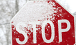 A stop sign is covered as heavy snow falls in Brampton, Ontario, on April 2, 2025. Environ...
