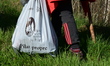 A woman collects litter in nature at the Doizieux Dam in the Pilat Regional Natural Park d...