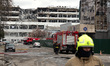 Firefighters and fire engines are in the street outside a building in the Obolonskyi distr...