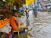 Vehicles try driving and Citizens waking through the flooded streets of Dhaka after heavy rainfalls caused a standstill in the streets to ve...