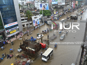 Vehicles try driving and Citizens waking through the flooded streets of Dhaka after heavy rainfalls caused a standstill in the streets to ve...