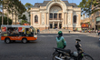 A local electric buggy and a motorbike pass in front of the Municipal Opera House, a Frenc...