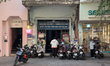 Motorbikes line the sidewalk in front of a small convenience store and neighboring busines...