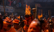 A Nepali reveler carries a sacred light torch during the annual Sindoor Jatra festival in...