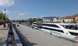 People walk and relax along the Danube promenade next to the docked river cruise ship Kris...