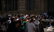 Visitors wait in line to enter St. Peter's Square near the Vatican, following the Pope's d...