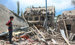 A boy stands near the debris of a demolished house related to the family of Ahsan Ul Haq S...